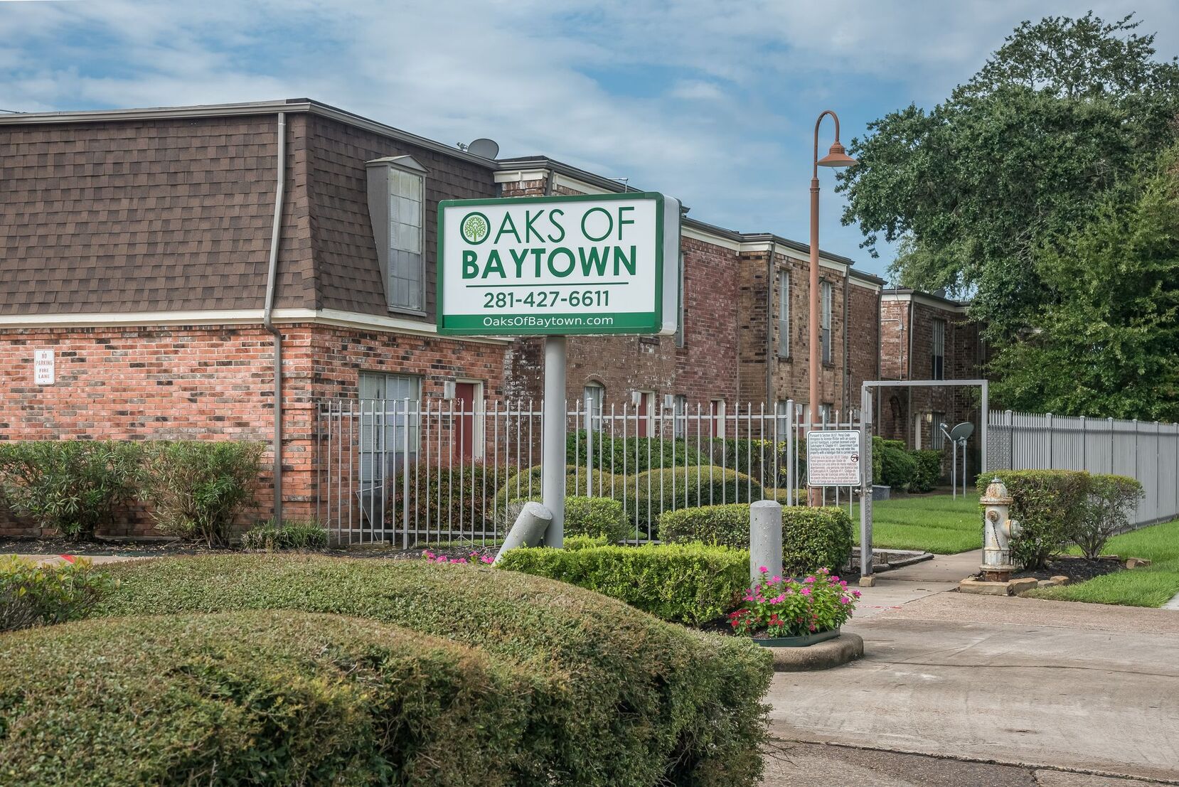 Exterior view of Oak of Baytown Apartments in Houston, TX, featuring contemporary design and well-maintained green spaces.